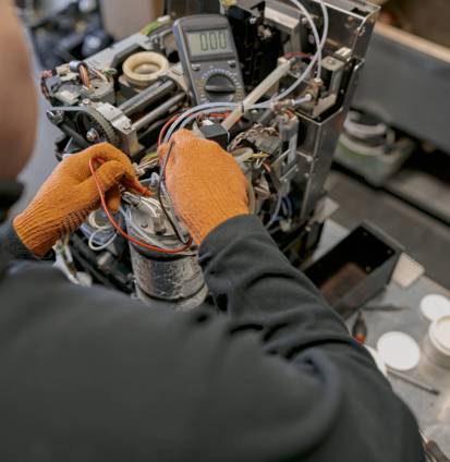 Close up of professional worker fixing coffee machine in workshop. High quality photo