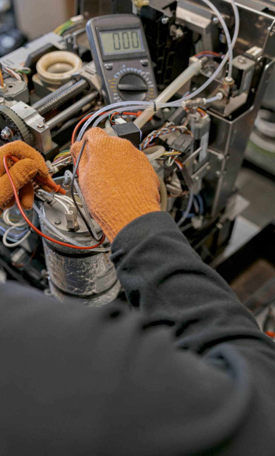 Close up of professional worker fixing coffee machine in workshop. High quality photo