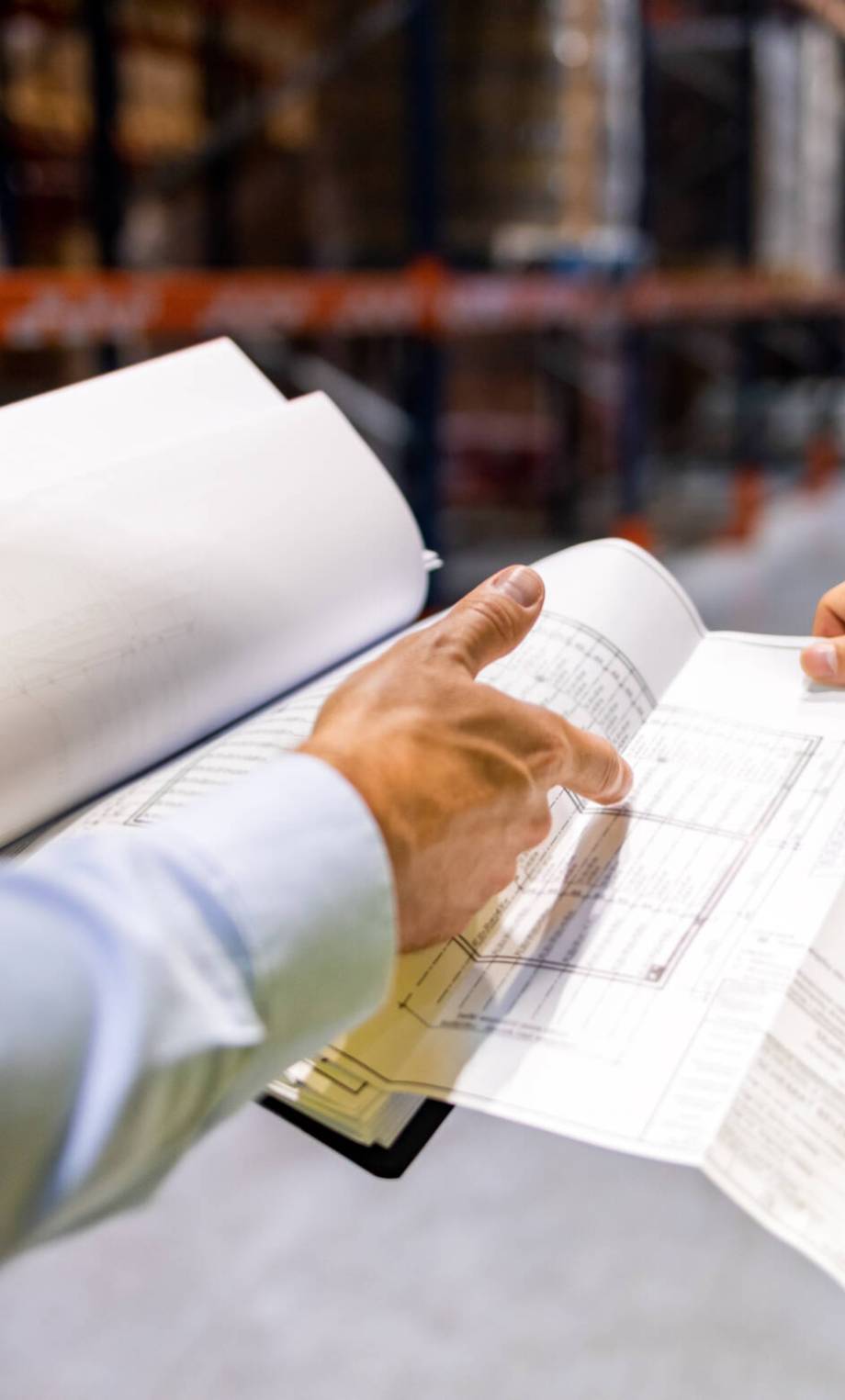 Warehouse workers checking inventory with plans in hand